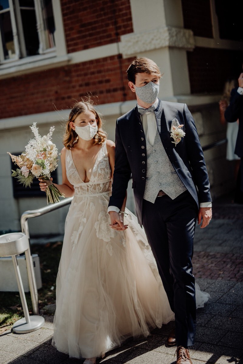 Hochzeit in Coronazeiten, Paar mit Masken, Brautstrauß, Corona